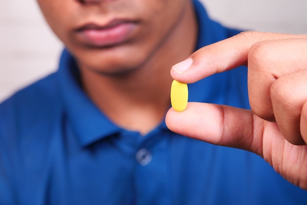 Cerca de la mano del hombre sosteniendo pastillas con espacio de copia.