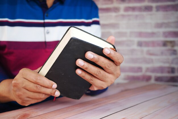 Foto cerca de la mano del joven leyendo un libro