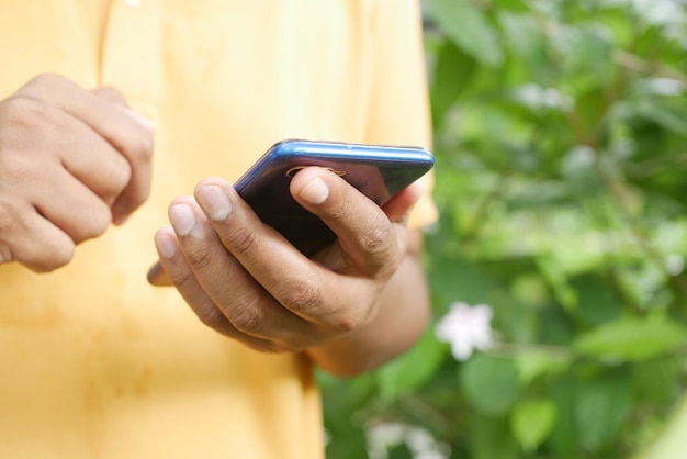 Foto cerca de la mano del joven con teléfonos inteligentes.