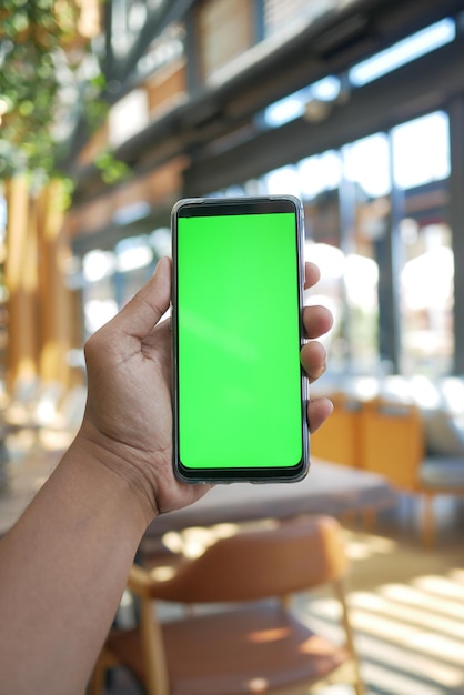 Cerca de la mano del joven con teléfonos inteligentes.