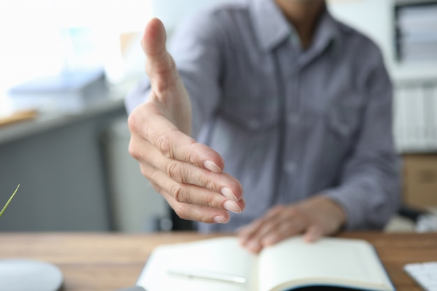 Cerca de la mano masculina para un apretón de manos en la oficina