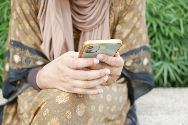 Cerca de la mano de la mujer sosteniendo un teléfono inteligente.