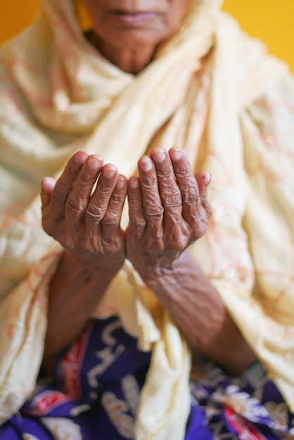Cerca de la mano de las mujeres mayores rezando en el ramadán