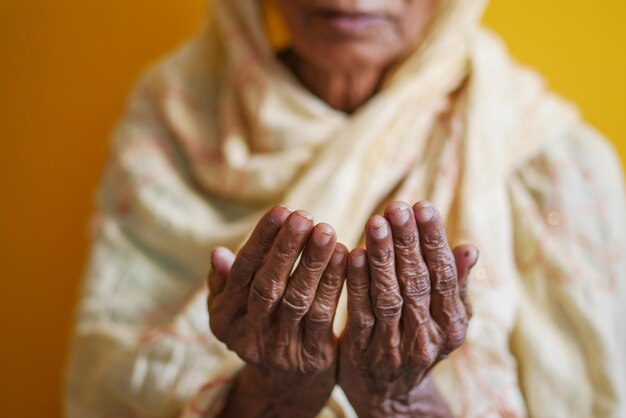 Cerca de la mano de las mujeres mayores rezando en el ramadán