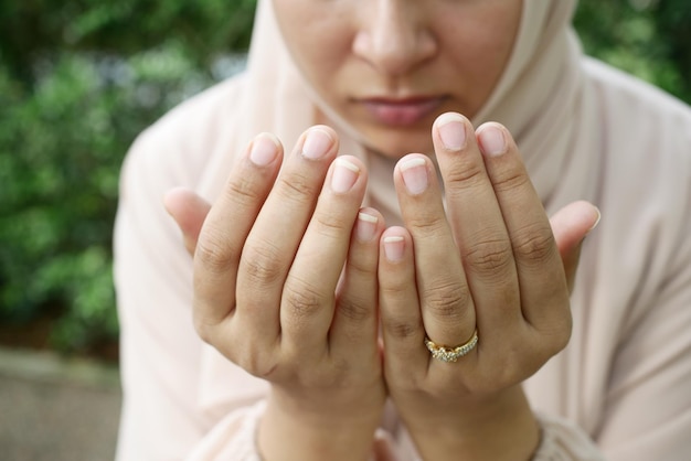 Cerca de la mano de las mujeres musulmanas rezando en el ramadán