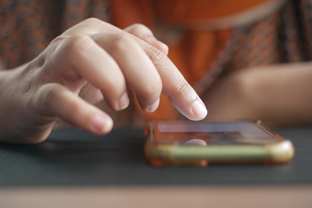 Cerca de la mano de las mujeres sosteniendo un teléfono inteligente