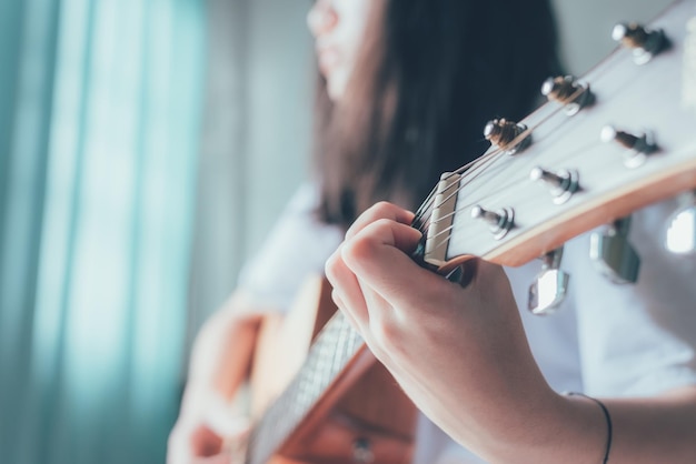 Cerca de la mano de las mujeres tocando la guitarra