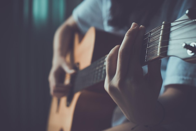 Cerca de la mano de las mujeres tocando la guitarra