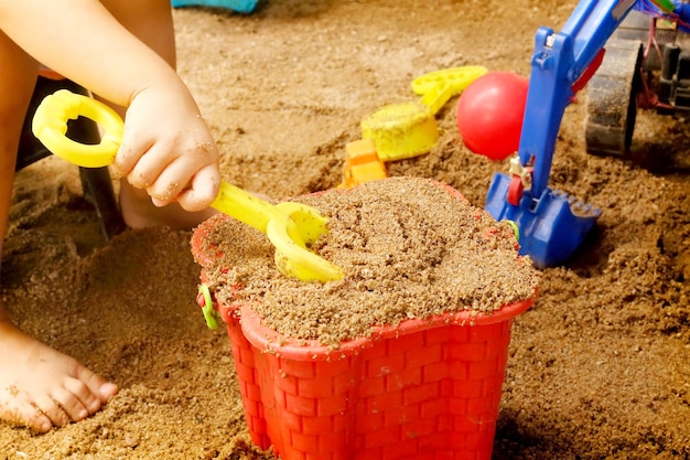 Cerca de la mano de un niño jugando juguetes de arena.
