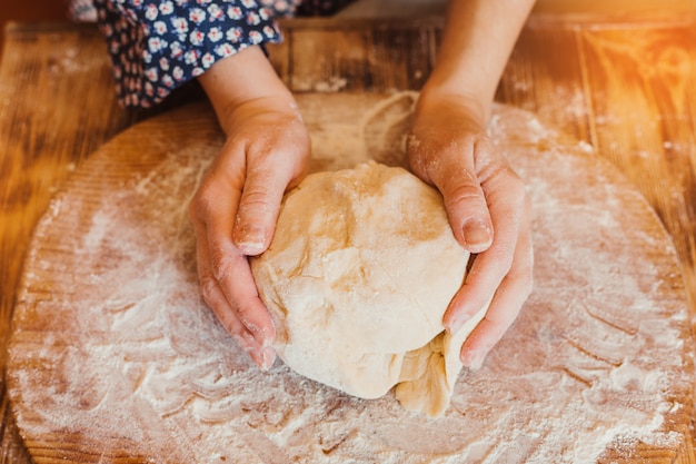 Cerca de la mano de un panadero femenino con masa recién amasada