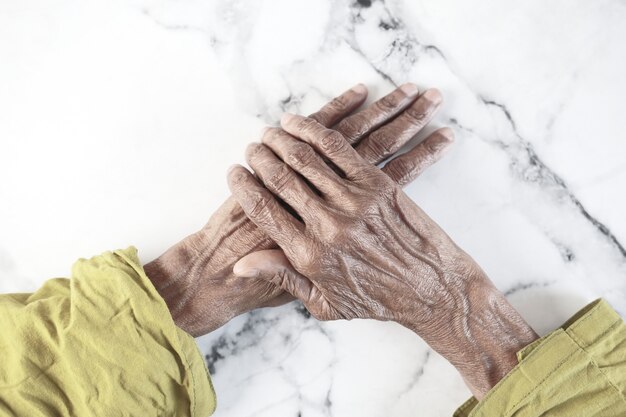 Foto cerca de la mano de una persona mayor aislada en blanco