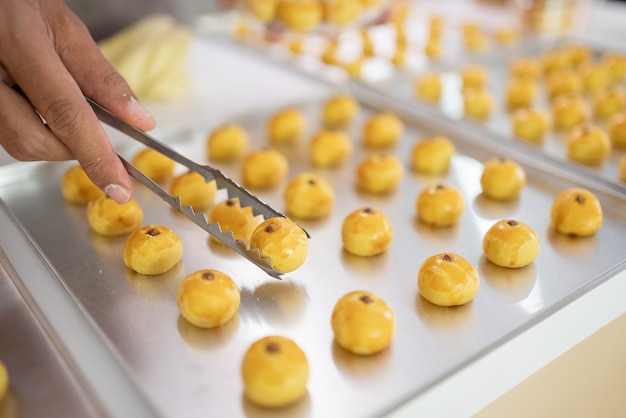 Cerca de la mano recogiendo tarta tarta nastar en una bandeja