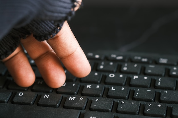 Cerca de la mano robando datos de la computadora portátil de arriba hacia abajo
