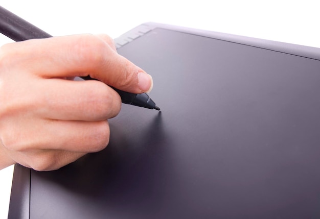 Cerca de una mano sosteniendo un bolígrafo y dibujando en una tableta