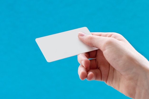 Foto cerca de una mano sosteniendo una tarjeta de presentación blanca en blanco con espacio de copia