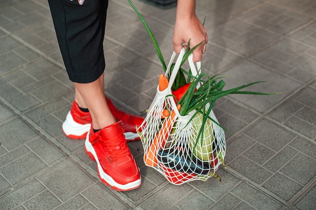 Foto cerca de las manos agarrando la bolsa con verduras orgánicas