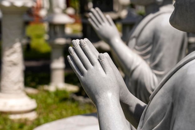 Cerca de las manos de la estatua de Buda de piedra en un templo budista Vietnam