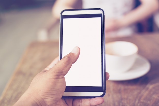 Cerca de las manos hombre usando el teléfono en la cafetería con profundidad de campo