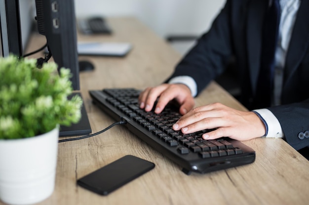 Cerca de manos masculinas usando la computadora en la oficina