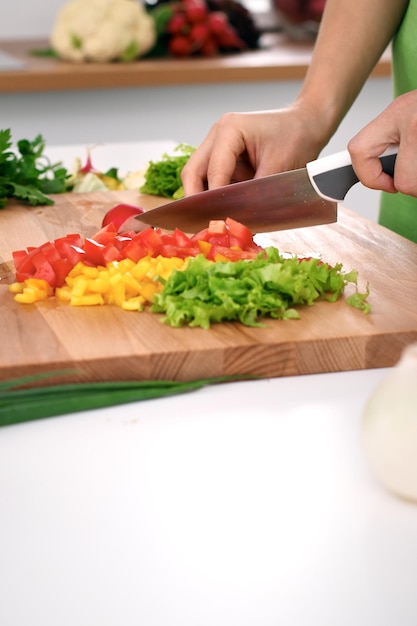 Cerca de las manos de la mujer cocinando en la cocina