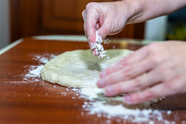 Cerca de manos de mujer haciendo masa para pan casero