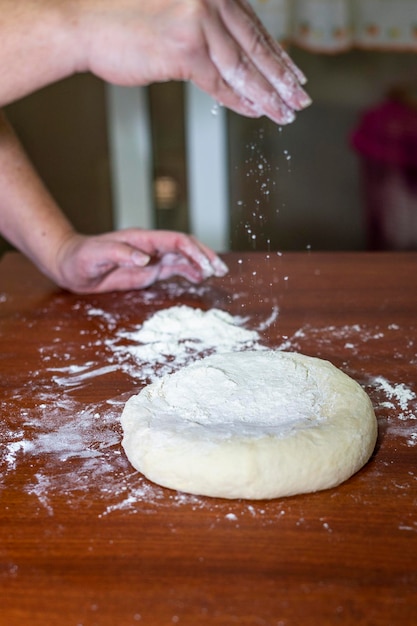 Cerca de manos de mujer haciendo masa para pan casero