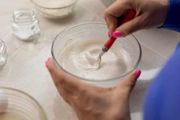 Cerca de manos de mujer mezclando levadura para hacer pan