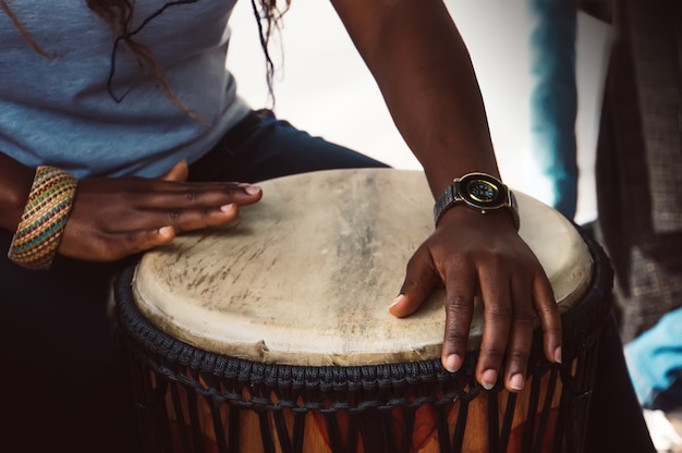 Cerca de las manos de una mujer tocando un tambor.