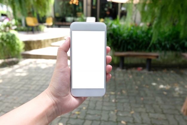 Cerca de las manos de las mujeres la celebración de teléfono celular en blanco copia espacio pantalla. teléfono inteligente con el concepto de tecnología