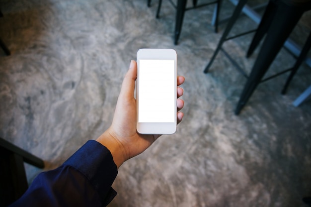 Cerca de las manos de las mujeres la celebración de teléfono celular en blanco copia espacio pantalla. teléfono inteligente con el concepto de tecnología