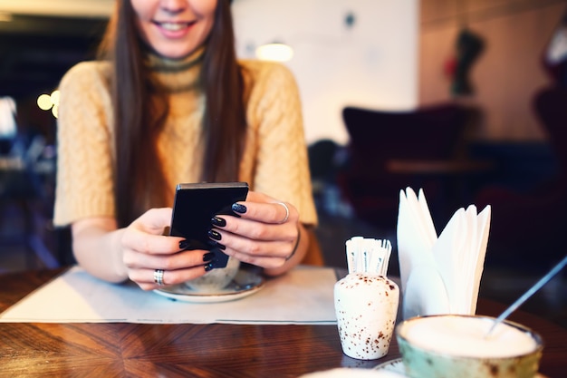 Cerca de las manos de las mujeres con teléfono celular