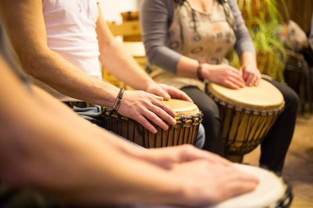 Foto cerca de las manos en tambores africanos, tocando la batería para una musicoterapia