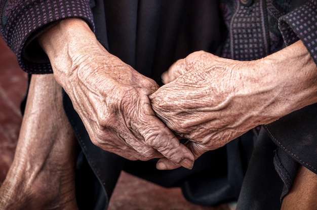 Cerca de las manos de la vieja persona no identificada