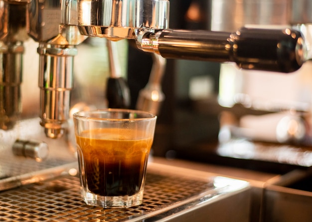 Cerca de la máquina de café está preparando café en la cafetería.