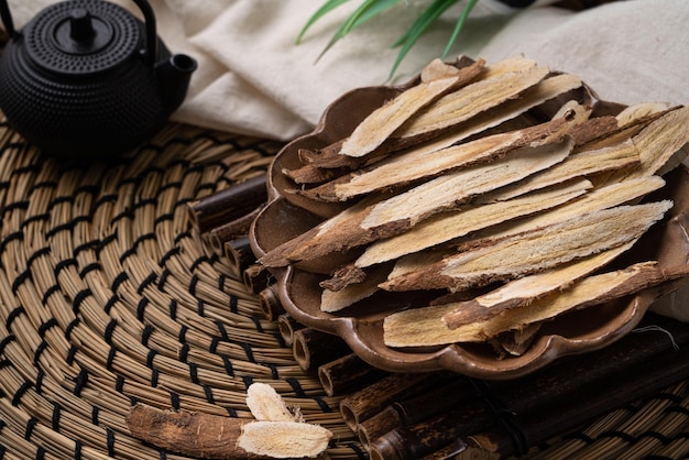 Cerca de la medicina tradicional china a base de hierbas raíz de astrágalo sobre fondo de mesa de madera.