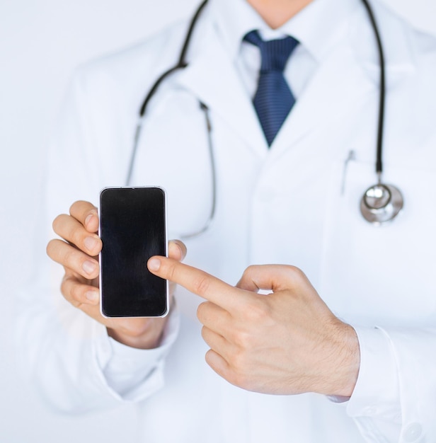 Cerca del médico varón apuntando al smartphone