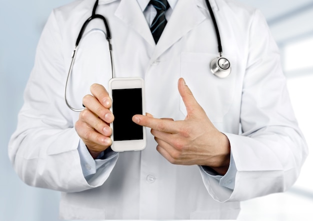 Cerca del médico varón apuntando al smartphone