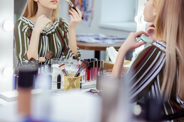 Cerca de una mesa con una gran cantidad de cosméticos sobre ella