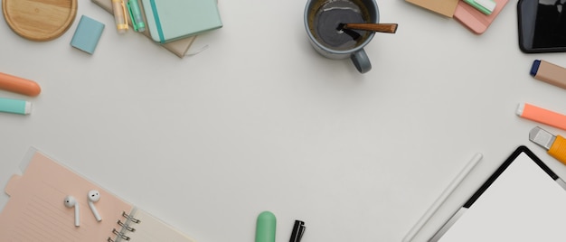 Cerca de la mesa de trabajo mínima con tableta y taza de café