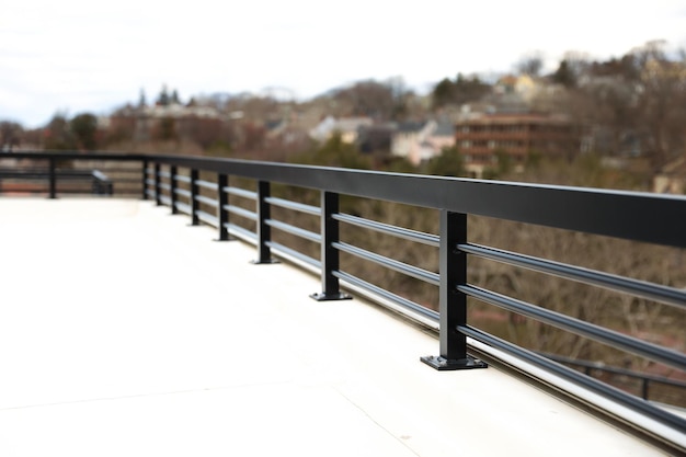 Una cerca de metal negro está en un puente en la ciudad.