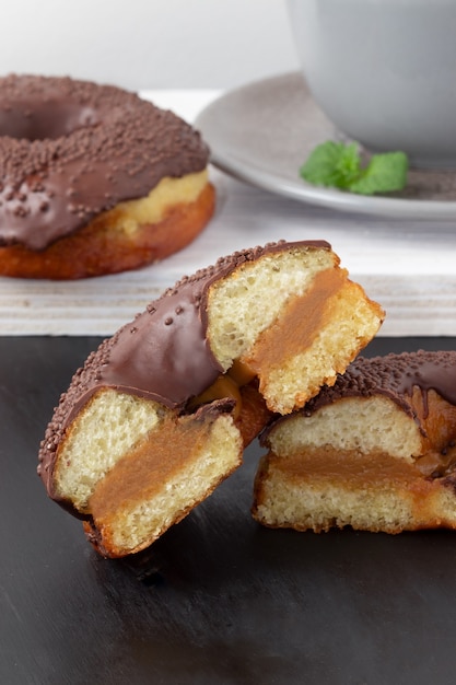 Cerca de las mitades de deliciosas donas de chocolate rellenas de dulce de leche.