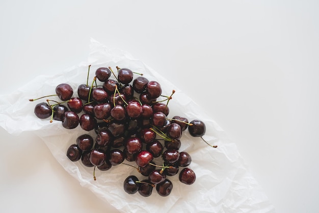 Cerca de un montón de cerezas maduras con tallos de cerezas rojas frescas Fondo de cerezas maduras