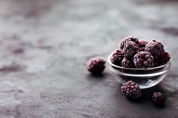 Cerca de moras congeladas sobre un fondo oscuro, alimentos saludables, vitaminas, postre snack