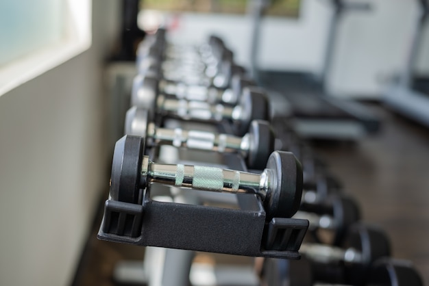 Cerca de muchas pesas en el gimnasio deportivo