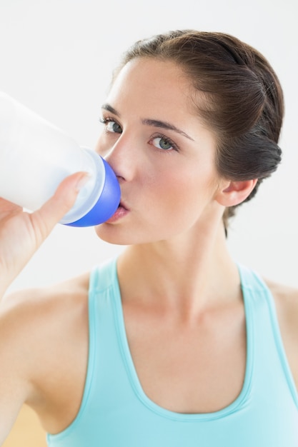 Cerca de una mujer de agua potable en el gimnasio