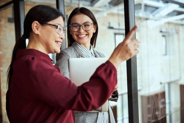 Cerca de una mujer amable divirtiéndose durante el trabajo