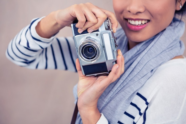 Cerca de la mujer asiática sonriente tomando fotografía con cámara