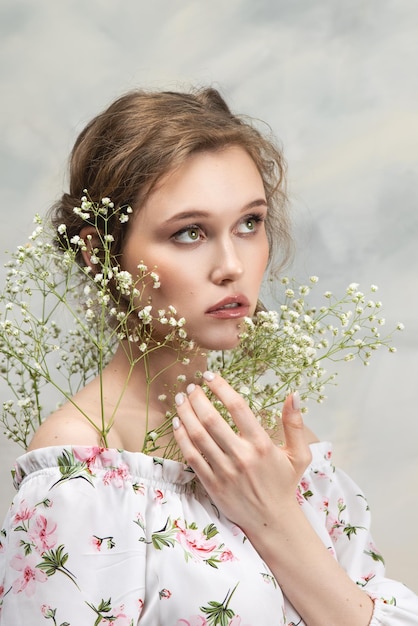 Cerca de mujer feliz oliendo flores silvestres Ser femenino con la naturaleza