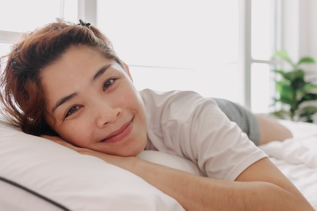 Cerca de mujer feliz simplemente despierta en la cálida mañana de verano