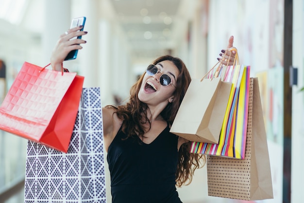 Cerca de mujer joven con bolsas de compras del Viernes Negro